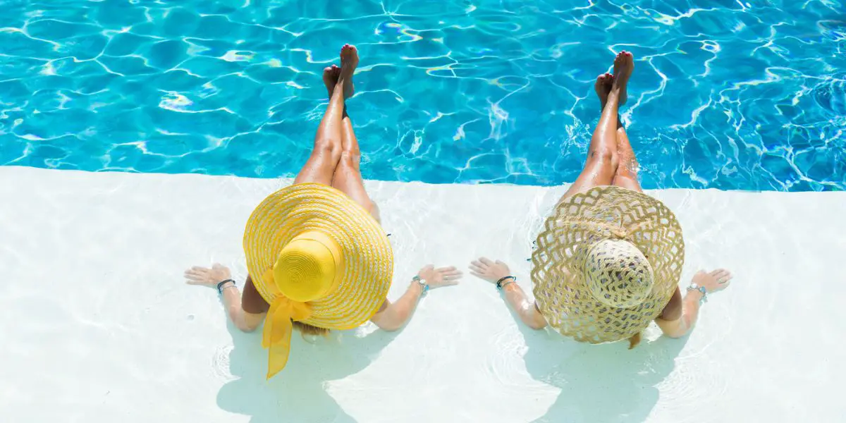 Nude by the pool with large hat