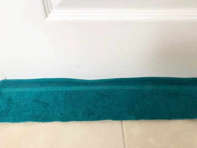 Damp towel at base of bathroom door